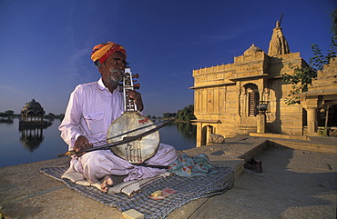 Busking at Gadi Sagar with Hindu temple, Jaisalmer, Rajasthan, India, Asia