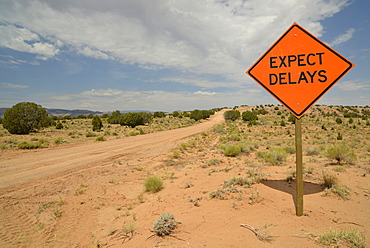 Sign, lettering "Expect delays", dirt road, Notom-Bullfrog Road, Capitol Reef National Park, Utah, USA