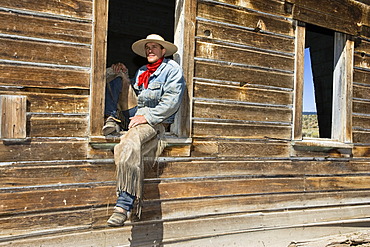 Cowboy sitting in barn window, wildwest, Oregon, USA