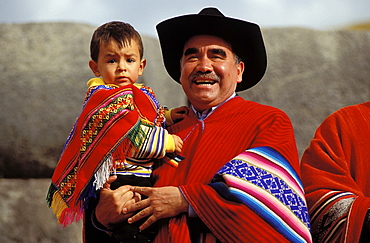 Man with child on his arm . father and son in typical clothes , Suedamerika, Peru, Anden