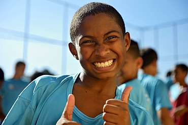 Boy making thumbs-up gesture, Guararape favela, Rio de Janeiro, Brazil, South America