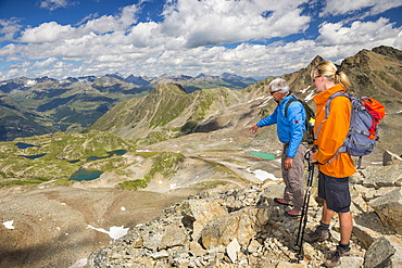 Two hikers on the Fuorcia da Barcli pass, overlooking the Macun Lakes, Swiss National Park, GraubÃ¼nden, Switzerland, Europe