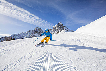 Skier with a helmet skiing down a slope, Mutterer Alm near Innsbruck, Tyrol, Austria, Europe