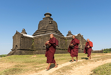 Buddhist monks collect morning alms in front of Laymyetnha Paya, Lemyethna Temple, Mrauk U, Burma, Myanmar, Asia