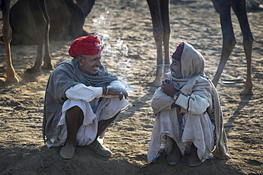 Two men having a break, Pushkar Camel Fair, Pushkar, Rajasthan, India, Asia