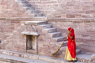 Woman in Sari cleaning the steps at Toorji Ka Jhalara, The Step Well, Jodhpur, Rajasthan, India, Asia