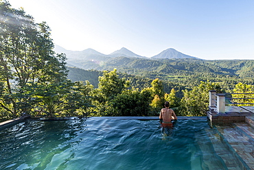 Man looking over the landscape, pool, Munduk, Bali, Indonesia, Asia