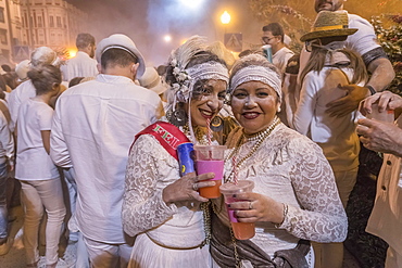 Two woman posing in front of crowd, white powder and white clothes, carnival La fiesta de los Indianos, Las Palmas de Gran Canaria, Canary Islands, Spain, Europe