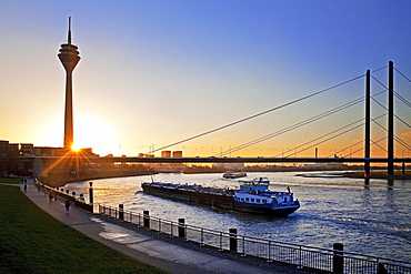 Rhine with cargo ship, Rhine Tower and Rheinkniebrücke, bridge at sunset, Düsseldorf, North Rhine-Westphalia, Germany, Europe