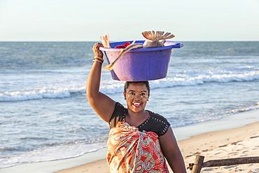 Malagasy woman carrying fish in a tub on her head, Morondava, Toliara province, Madagascar, Africa