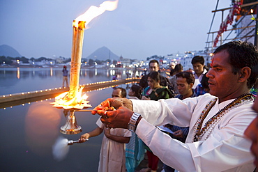 Brahmin conducting a religious ceremony, Aarti and Deepdan ceremony holding an oil lamp, sacred Pushkar Lake during the Pushkar Mela, Rajasthan, India, Asia