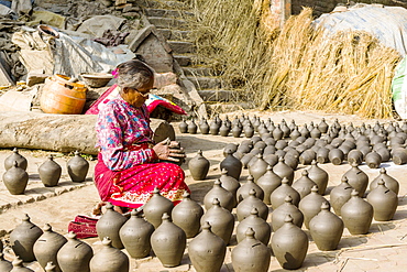 A woman is working at pottery in the streets, Bhaktapur, Kathmandu, Nepal, Asia