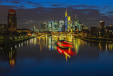 Trail of light from boat in front of skyline, blue hour, Osthafen, Frankfurt am Main, Hesse, Germany, Europe