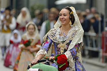 Fallas festival, young woman in a traditional costume during the parade in the Plaza de la Virgen de los Desamparados, Valencia, Spain, Europe