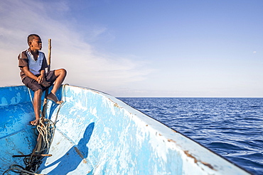 Boy on a fishing boat looking out to the sea, Yasawa Islands, Fischi