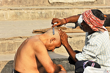 Ritual hair cutting on the Ganges, Varanasi, Benares, Uttar Pradesh, India, Asia