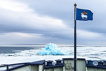 Flag of Gotland, Blue Iceberg drifting in Hinlopen Strait, Spitsbergen Island, Svalbard archipelago, Norway, Europe