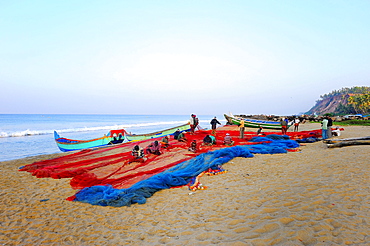 Fishermen repairing nets on the beach, Arabian Sea, Varkala, Kerala, South India, India, Asia