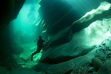 Diver looking at traces of erosion on the riverbed of the Verzasca River, Lavertezzo, Valle Verzasca valley, Canton of Ticino, Switzerland, Europe