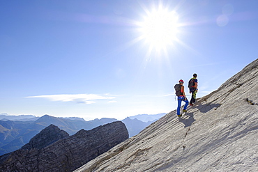 Mountain guide guiding a young woman on a short rope through a rock face, Wiederroute, Watzmann, Schonau am Konigsee, Berchtesgadener Land, Bavaria, Germany, Europe