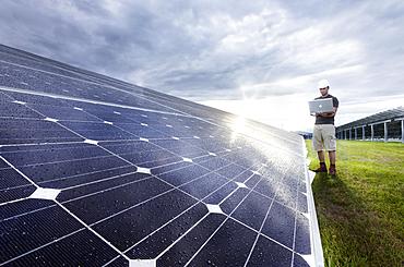 Solar installation technician checking solar panels with his laptop computer