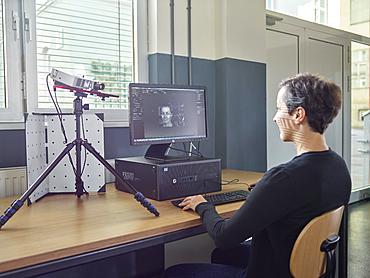 30-35 year old woman scans her head with a 3D scanner