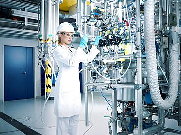 Chemielaborantin, chemist with helmet and goggles in a pharmaceutical production, Austria, Europe