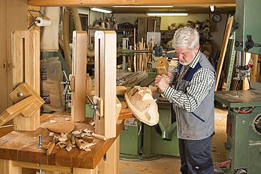 Wooden mask carver using wood carving tools on a wooden block, wooden mask carver, workbench, Bad Aussee, Styria, Austria, Europe