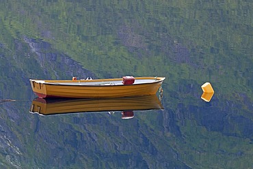 A small boat reflected in the calm Norwegian Sea near Straumsbotn on the island of Senja, HÃ‚verjorda, Haverjorda, Troms, Norway, Europe