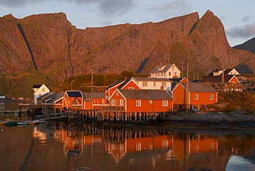 Rorbuer huts, rorbu, of the tiny village Sakrisoy, Sakrisoy, mountains at back, island of Moskenesoy, Moskenesoy, Lofoten archipelago, Nordland, Norway, Europe