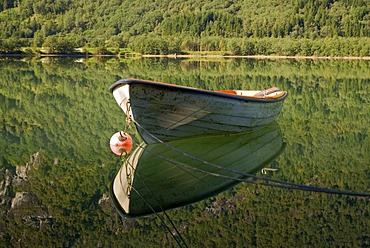 Lone boat reflected in the calm water of the small lake Bergheimsvatnet, Egge, Byrkjelo, Sogn og Fjordane, Norway, Europe