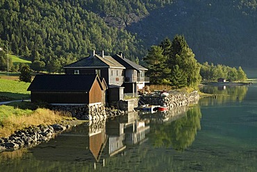 Houses at the shore of lake Strynevatnet, reflected in the calm water, Storesunde, Sogn og Fjordane, Norway, Europe