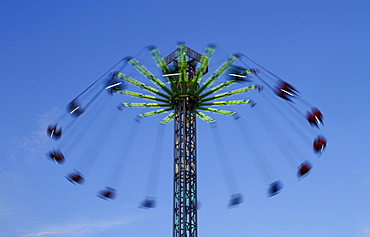 Carousel against a blue sky, blurred