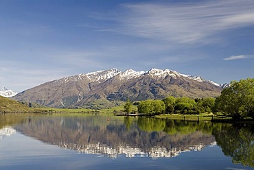 Mountains of the southern alps, reflected in the calm waters of Lake Wanaka, South Island, New Zealand