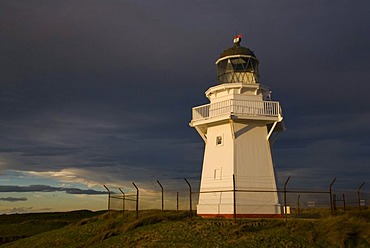 Waipapa Point Lighthouse in evening light with dark clouds at back, Otara, Fortrose, Southland, New Zealand