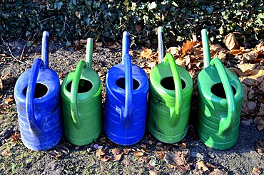 Several blue and green watering cans, cemetery, Borken, Muensterland, North Rhine-Westphalia, Germany, Europe