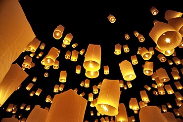 Traditional fire lanterns being released into the night sky during the Yeepeng festival, also referred to as Loi Krathong, in Chiang Mai, Thailand, Asia