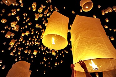 Traditional fire lanterns being released into the night sky during the Yeepeng festival, also referred to as Loi Krathong, in Chiang Mai, Thailand, Asia