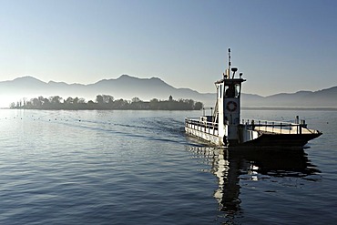 Vehicle transport boat and Fraueninsel island in early morning light, lake Chiemsee, Chiemgau, Upper Bavaria, Germany, Europe