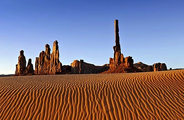 Sand dunes in front of Totem Pole and Yei Bi Chei rock formations after sunrise, Monument Valley, Navajo Tribal Park, Navajo Nation Reservation, Arizona, Utah, United States of America, USA