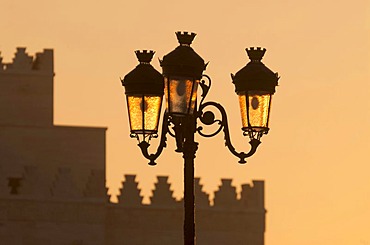 Backlit street lamps in front of the silhouette of the mausoleum of King Mohammed V, Rabat, Morocco, Africa