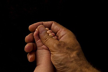 Father's hand holding baby's hand