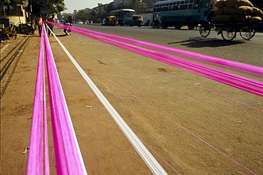 Preparing the kite threads with color and glass powder to cut the other kites off the sky, preparations for the annual kite festival in Ahmedabad, Gujarat, India, Asia