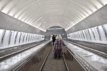 Woman going down an escalator down to the metro, Prague, Bohemia, Czech Republic, Europe