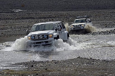 Super jeeps driving through a tributary of the Krossa River, ï¬orsmoerk, Iceland, Europe