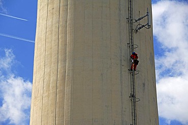 Chimney of Erlanger Stadtwerke heating plant, workman scaling chimney for repair works, Aussere Brucker Strasse 33, Elangen, Middle Franconia, Bavaria, Germany, Europe