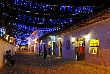 Alleyway with chains of lights in Villa de Leyva in the evening, colonial buildings, Boyaca department, Colombia, South America