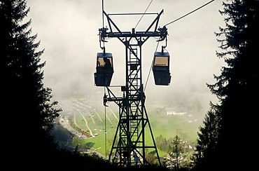 Cars and pylons of the Jennerbahn cable car in front of the intermediate station with view of Schoenau am Koenigssee in morning mist, Berchtesgadener Land, Bavaria, Germany, Europe