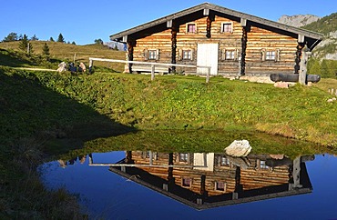 Wooden cabin reflected in a small pond, Gotzenalm alp, Schoenau, Koenigsee, Berchtesgadener Land, Bavaria, Germany, Europe