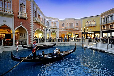 Gondolier in a gondola to attract tourists in simulated Venetian alleys under an artificial sky, Canale Grande, 5-star luxury hotel, The Venetian Casino, Las Vegas, Nevada, United States of America, USA